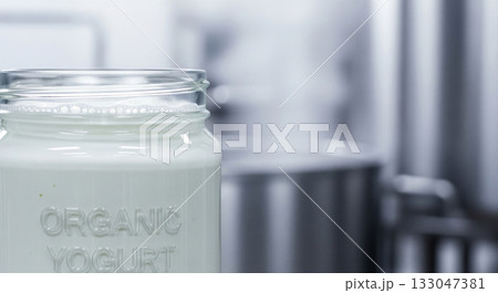 Organic Greek yogurt sits smoothly in a clear glass jar, showcasing its creamy texture. A steel kitchen backdrop highlights this fresh dairy product, emphasizing its homemade appeal. Organic Greek yogurt sits smoothly in a clear glass jar, showcasing its creamy texture. A steel kitchen backdrop highlights this fresh dairy product, emphasizing its homemade appeal. 133047381