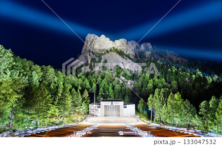 Mount Rushmore National Memorial illuminated at night by spotlights. The Grand View Terrace amphitheater and seating are in the foreground 133047532