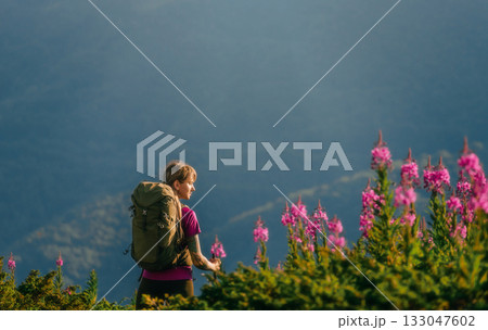 Woman with Tourist Backpack Hiking in Mountains 133047602