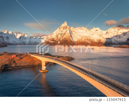 Aerial view of Hamnoy bridge and snowy rocks at sunrise Aerial view of Hamnoy bridge and snowy rocks at sunrise 133047913