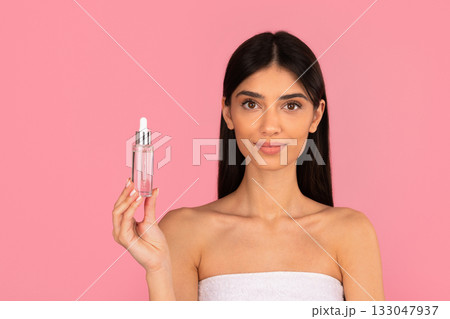 Young beautiful woman with clean fresh skin holding glass serum bottle Young beautiful woman with clean fresh skin holding glass serum bottle 133047937