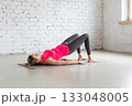 Slim Caucasian woman practice shoulder bridge indoor in loft studio. 133048005