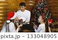 A family is celebrating Christmas together by a decorated tree 133048905