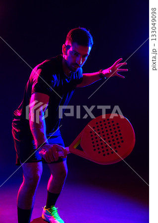 Player practicing pickleball in colorful lighting during an indoor training session 133049098