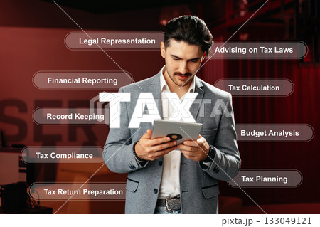 Professional advisor reviewing tax-related tasks in an office setting during the day Professional advisor reviewing tax-related tasks in an office setting during the day 133049121