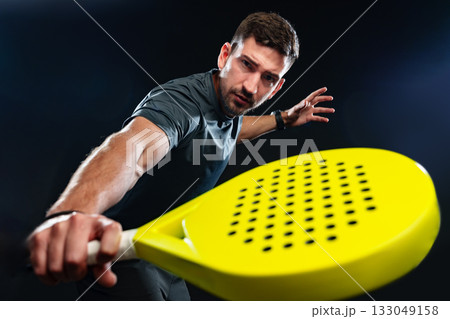 Man demonstrating pickleball skills with a yellow paddle in a dramatic setting Man demonstrating pickleball skills with a yellow paddle in a dramatic setting 133049158