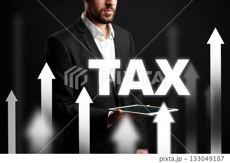 Businessman presenting tax growth concept using a tablet with upward arrows in background Businessman presenting tax growth concept using a tablet with upward arrows in background 133049187