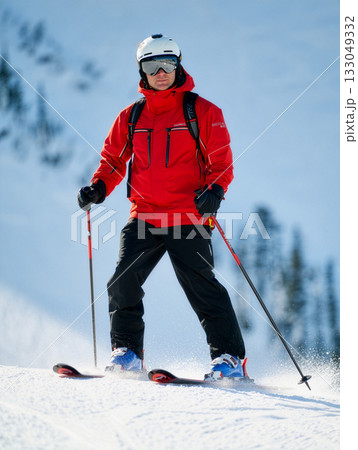 Skiing on a sunny winter day in the mountains with snow-covered slopes and clear blue skies 133049332