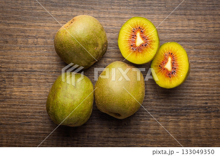 Red kiwi fruit on wooden table. Top view. 133049350