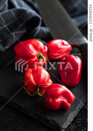 Red chili pepper habanero on black table. 133049354