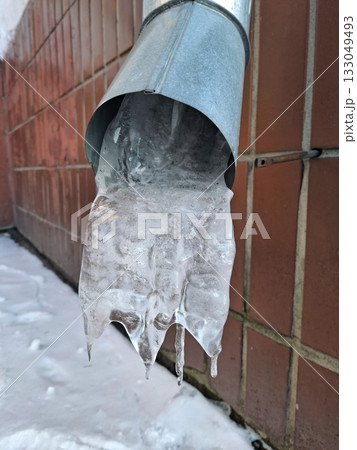 Ice in the building downspout. Rainwater drainage pipe froze over the winter 133049493