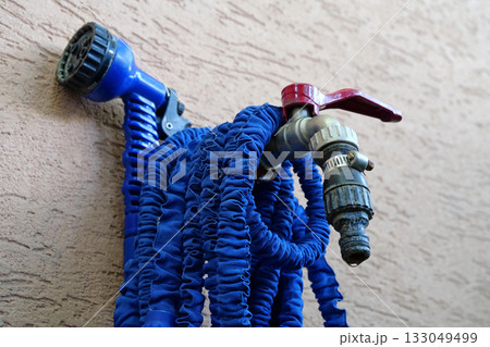 Outdoor tap for watering a garden plot. Water tap outside the building 133049499