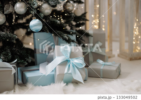 Christmas trees with blue and silver ornaments and gift boxes on white wooden floor Christmas trees with blue and silver ornaments and gift boxes on white wooden floor 133049502