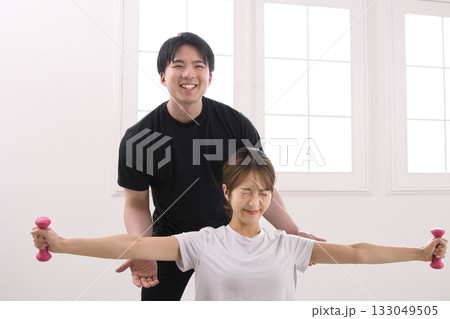 パーソナルトレーナーにトレーニングを受ける若い女性 パーソナルトレーナーにトレーニングを受ける若い女性 133049505