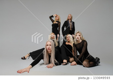Group of women in black outfits posing creatively in a studio setting for fashion photography 133049593