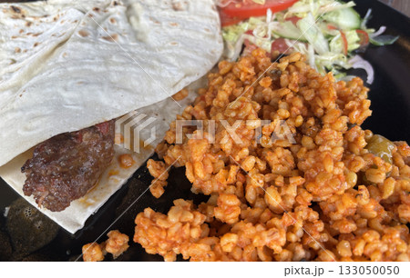 Turkish chicken kebab with bulgur, salad and lavash close up Turkish chicken kebab with bulgur, salad and lavash close up 133050050