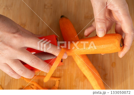 Fresh Carrot Peeling with Knife Close Up, Raw Carrot Slices, Orange Root Vegetable 133050072