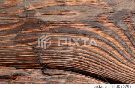 Old wood textured background. Dark driftwood surface, burnt wood brushing, macro brown floor Old wood textured background. Dark driftwood surface, burnt wood brushing, macro brown floor 133050295