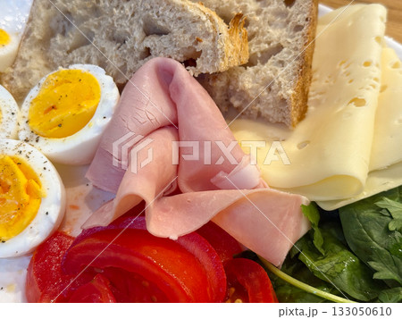 Morning plate with eggs, vegetables and bread on wooden table. Healthy diet, homemade breakfast, and natural nutrition balance. Morning plate with eggs, vegetables and bread on wooden table. Healthy diet, homemade breakfast, and natural nutrition balance. 133050610