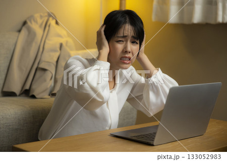 夜リビングでパソコンを見る若い女性 夜リビングでパソコンを見る若い女性 133052983