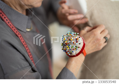 Elderly woman's hands sewing on mannequin 133053540