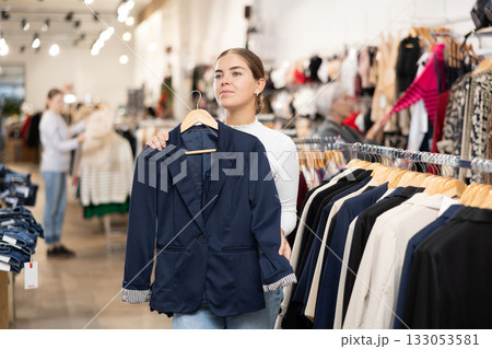 Young girl choosing convenient blazer in clothing store Young girl choosing convenient blazer in clothing store 133053581