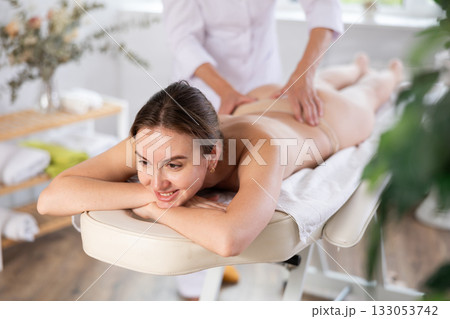 Young woman clinet satisfied with work of masseuse Young woman clinet satisfied with work of masseuse 133053742