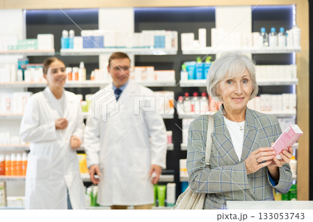 In pharmacy, senior female customer chooses cream for aging skin In pharmacy, senior female customer chooses cream for aging skin 133053743