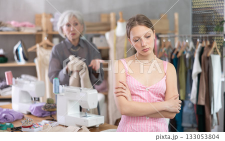 Mature dressmaker scolds assistant at work 133053804