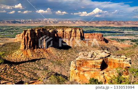Scenic view from Grand View in Colorado National Monument. The Monument mesa is in the center, overlooking the Grand Valley and Book Cliffs under a dramatic cloudy sky 133053994