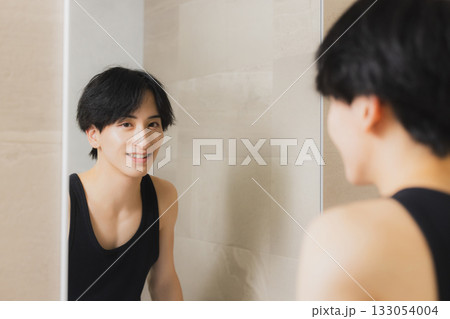 鏡を見る若い男性 133054004