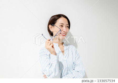 メガネを手に取る女性 133057534