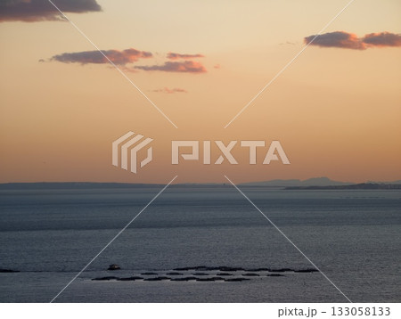 relaxing sunset over smooth water with subtle cloud formations and minimalistic design elements 133058133