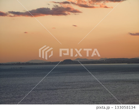 serene sunset panorama, tranquil evening coastal view, peaceful horizon with distant land 133058134
