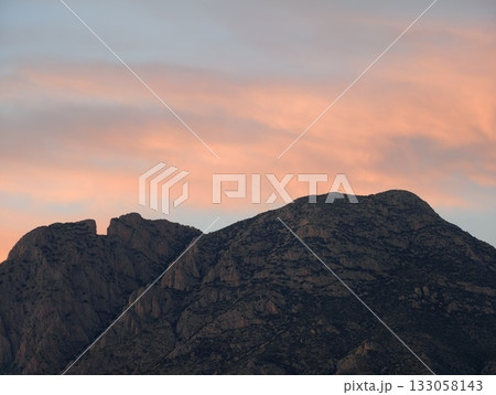 scenic dusk illuminated rocky summit, majestic granite summit glowing under vibrant sunset sky 133058143