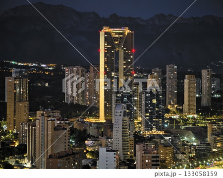 nighttime urban scene featuring glowing structure amidst rugged mountains and illuminated skyline nighttime urban scene featuring glowing structure amidst rugged mountains and illuminated skyline 133058159