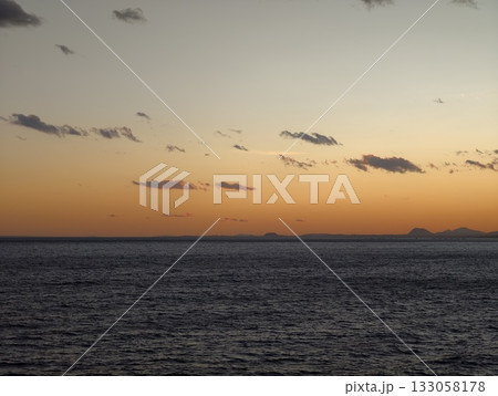 peaceful water scene during evening twilight, quiet ocean horizon bathed in gentle evening glow 133058178