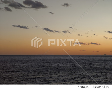 remote crag amidst tranquil ocean hues, secluded rocky outcrop treasuring warm atmospheric shades 133058179