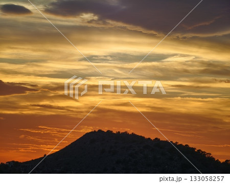 crimson horizon with swirling cloud formations, dramatic evening sky illuminated by fiery hues crimson horizon with swirling cloud formations, dramatic evening sky illuminated by fiery hues 133058257