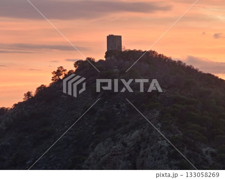 vivid sunset imagery, bold silhouette against intense sunset backdrop with contrasting clouds 133058269