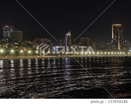 modern architecture silhouettes alongside ferries and traffic illuminate bustling metropolitan 133058286