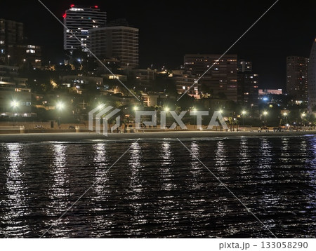 shimmering city lights and gentle waves, calm evening by harbor showcasing urban life and gentle shimmering city lights and gentle waves, calm evening by harbor showcasing urban life and gentle 133058290