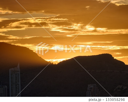 cinematic evening scene with silhouetted buildings and radiant sunset illuminating urban landscape 133058298