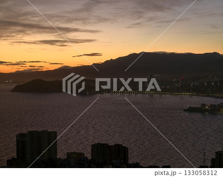 peaceful evening landscape, silent dusk over bay with silhouetted hills and gentle reflections peaceful evening landscape, silent dusk over bay with silhouetted hills and gentle reflections 133058312