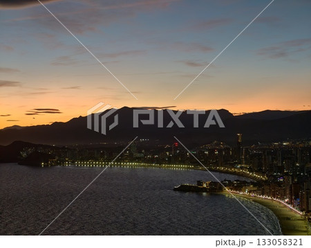 beautiful nighttime view of peaceful bay with shimmering water reflections and illuminated beautiful nighttime view of peaceful bay with shimmering water reflections and illuminated 133058321