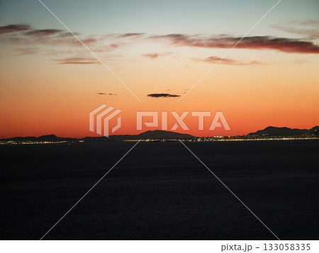 quiet horizon with city lights glowing faintly, peaceful evening with distant city skyline 133058335