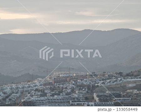 peaceful town with pastel skies, calm shoreline community with terraced rooftops and hazy mountains peaceful town with pastel skies, calm shoreline community with terraced rooftops and hazy mountains 133058449