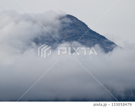 foggy mountain view, serene drone shot capturing secluded fogladen mountain ranges beneath cloudy 133058479