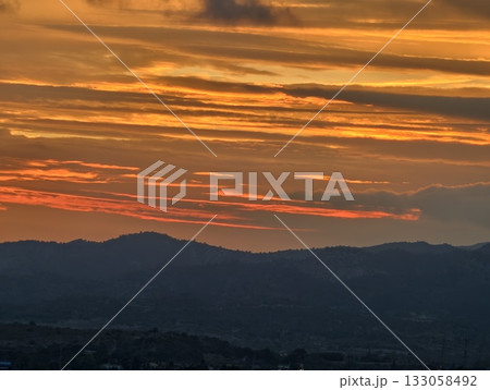 colorful evening scenery, vibrant sunset illuminates hills with dramatic cloud formations and hues colorful evening scenery, vibrant sunset illuminates hills with dramatic cloud formations and hues 133058492