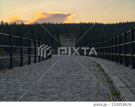 sunset illuminates textured footpath, golden sunset bathes stonebuilt pathway with inviting warmth 133058626